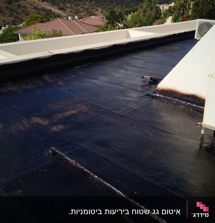 גג אטום בזפת שחורה עם קצוות לבנים